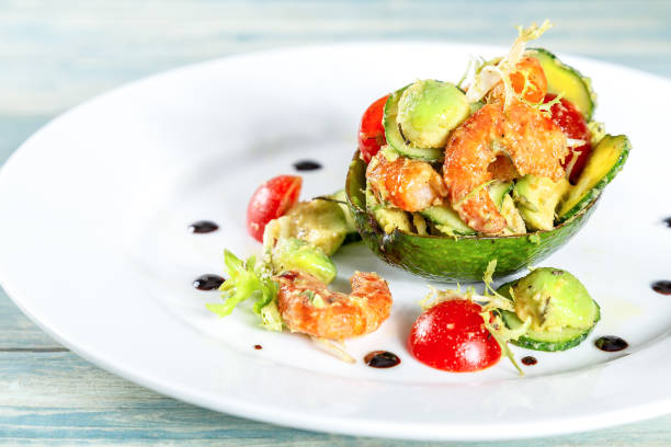 Plate of salad with shrimps, avocado and tomatos stock photo