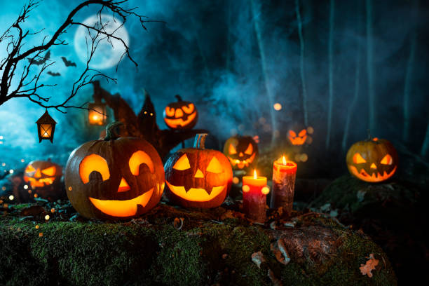 istock Halloween pumpkins on dark spooky forest. 1047635622