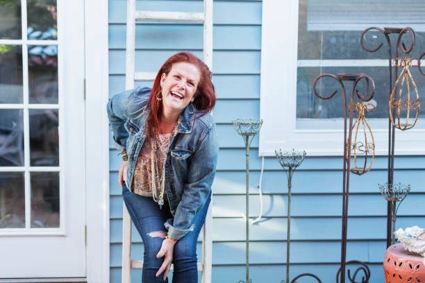 istock Mature woman outside her house, leaning against a ladder 1047635708