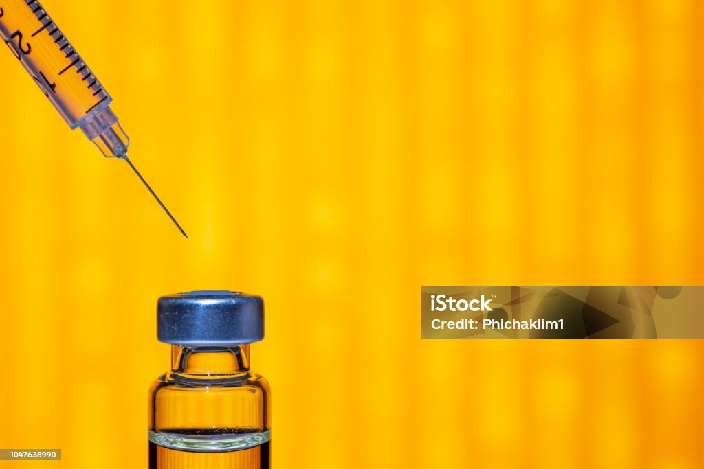A syringe with the needle point to the vaccine vial on the colorful abstract background Vaccination Stock Photo