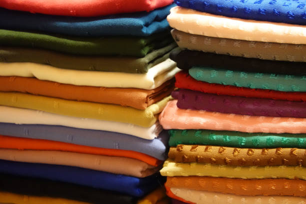 istock Stack with cloths and fabric in many different colours in one stall. 1047639148
