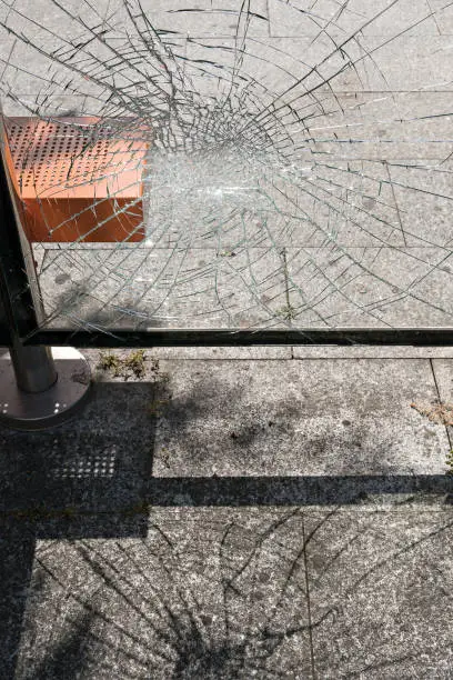 Vandalism, damaged glass at bus stop shelter