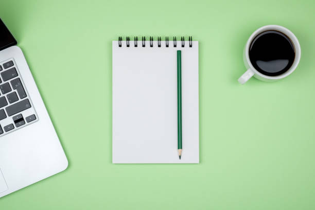 istock Minimal workplace with laptop and blank notepad on colored background. Top view. Flat lay 1047639884