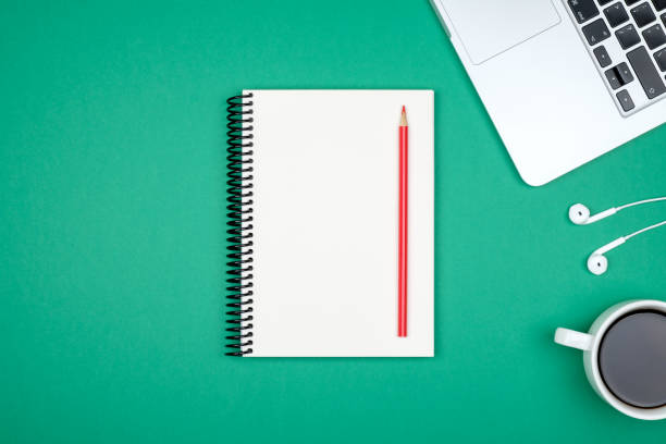 istock Minimal workplace with laptop and blank notepad on colored background. Top view. Flat lay 1047640128