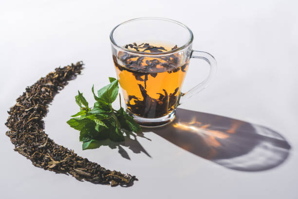 istock cup of black tea and mint on white tabletop 1047640438