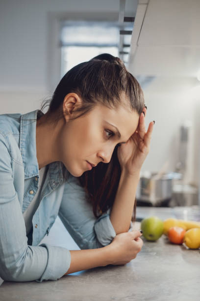 istock Angry girl with headache leaning on the kitchen countertop 1047640582