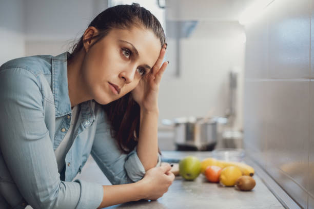 istock Sad girl leaning on the kitchen countertop 1047640624
