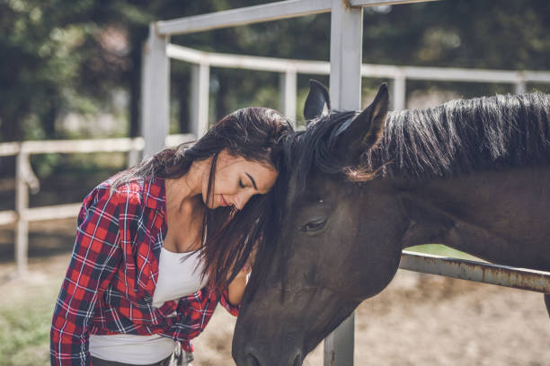 istock young woman and horse 1047643338