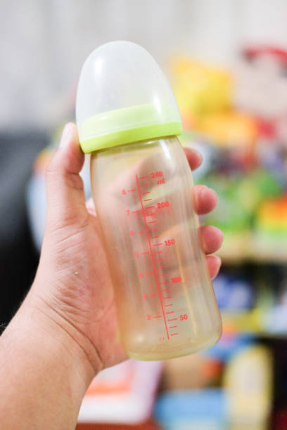 istock Clear baby bottle with rubber nipple in hand 1047644212