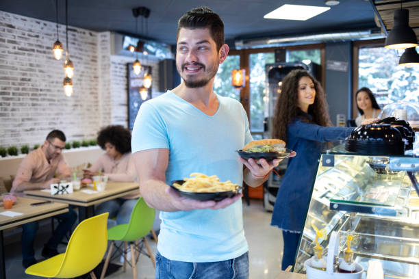 istock Man in front of showcase with fast food 1047644424