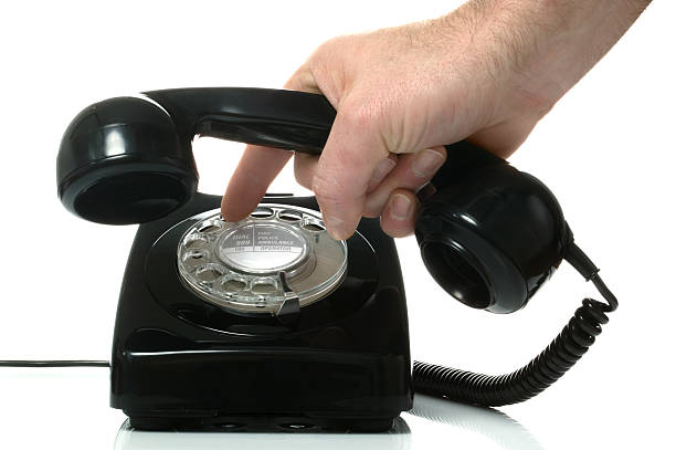 Dialling out Dialling a number on an old black retro phone. dialling phone stock pictures, royalty-free photos & images