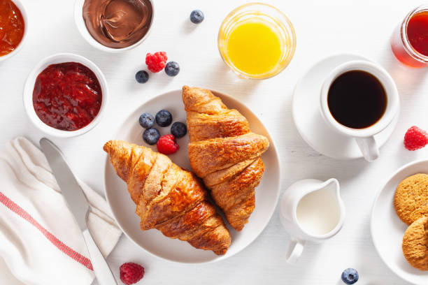 istock Continental breakfast with croissant, jam, chocolate spread and coffee. Top view 1047649916