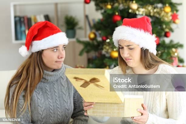 Disappointed Woman Receiving A Gift In Christmas Stock Photo - Download Image Now - Gift, Abandoned, Christmas Present