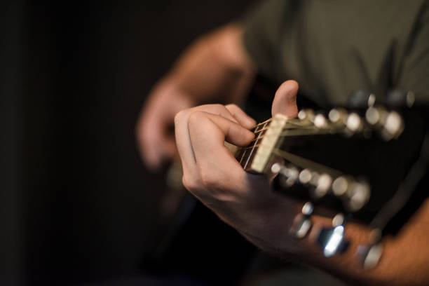 istock hands play on acoustic guitar 1047652694