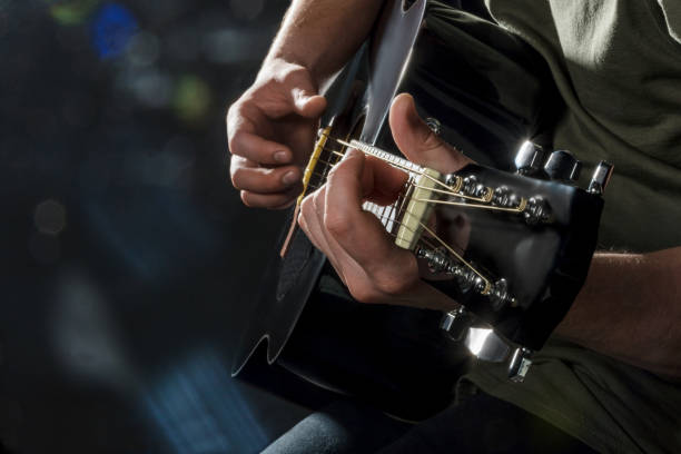 istock hands play on acoustic guitar 1047653246
