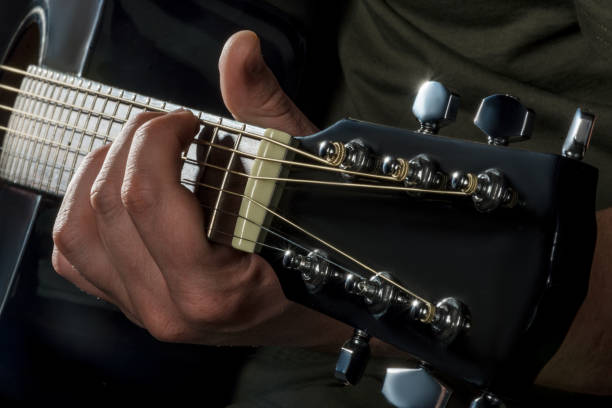 istock hands play on acoustic guitar 1047653264