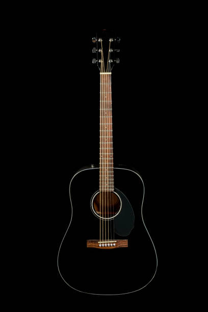 istock acoustic guitar on a black background 1047653362