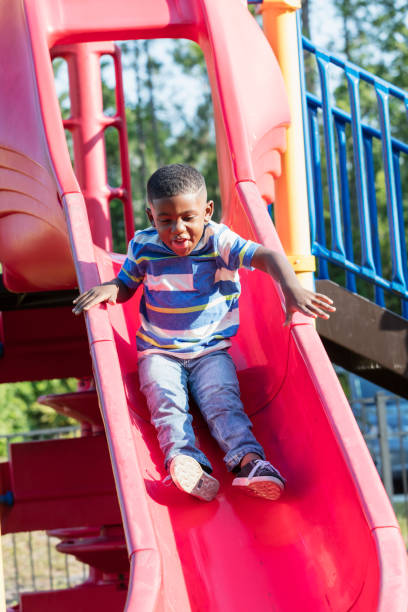 istock African-American boy on playground slide 1047653718