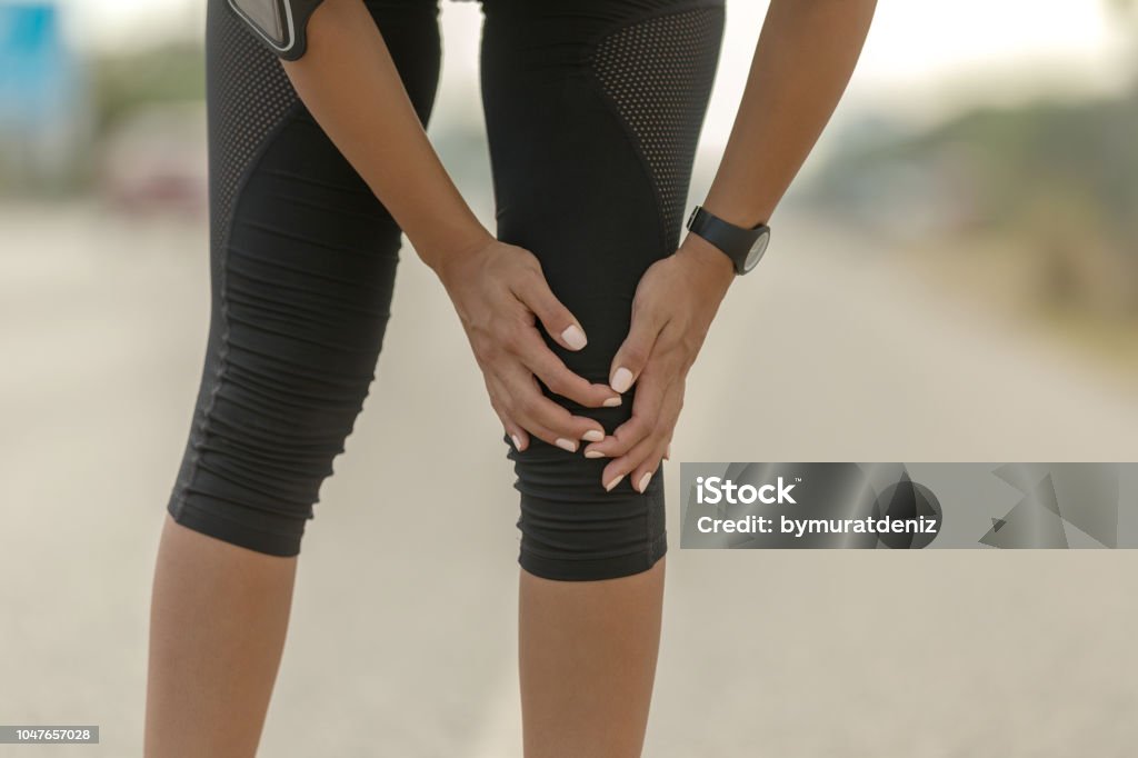 Femme tenant le genou douleur, douloureux et pénible jambe - Photo de Adulte libre de droits