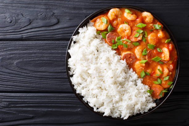 Delicious gumbo with prawns, sausage and rice  on a plate. Horizontal top view Delicious gumbo with prawns, sausage and rice on a plate on the table. horizontal top view from above stew photos stock pictures, royalty-free photos & images