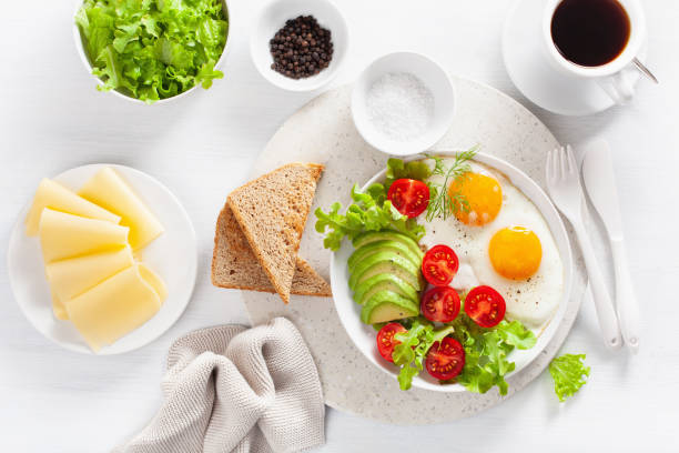 istock healthy breakfast flat lay. fried eggs, avocado, tomato, toasts and coffee 1047661002