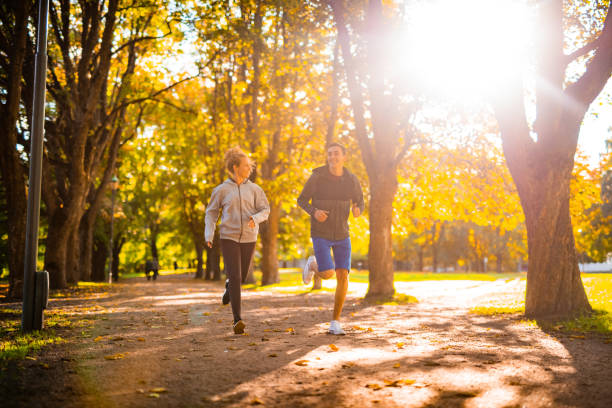 Smiling athletes running together in park.