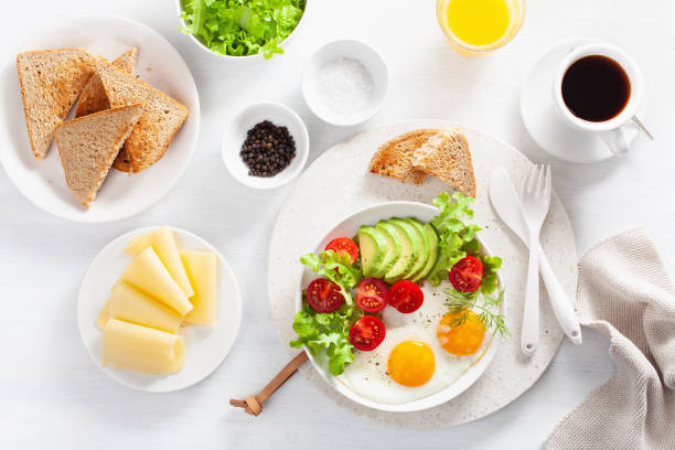 istock healthy breakfast flat lay. fried eggs, avocado, tomato, toasts and coffee 1047661214
