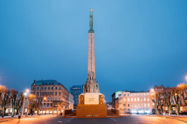 riga, letónia. visão noturna de memorial liberdade do monumento na praça da liberdade em noite iluminação iluminação - riga baltic countries europe night - fotografias e filmes do acervo