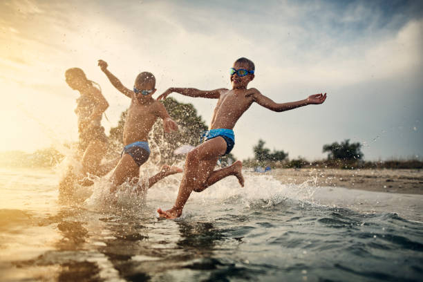 istock Kids having fun running into sea 1047668664