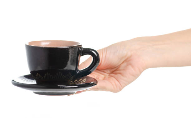 istock Black coffee cup and saucer in hand 1047669734