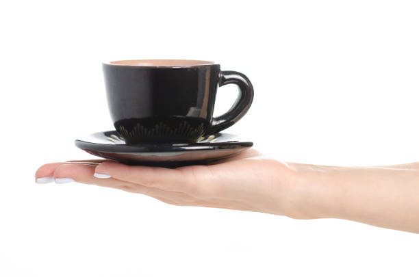 istock Black coffee cup and saucer in hand 1047669774