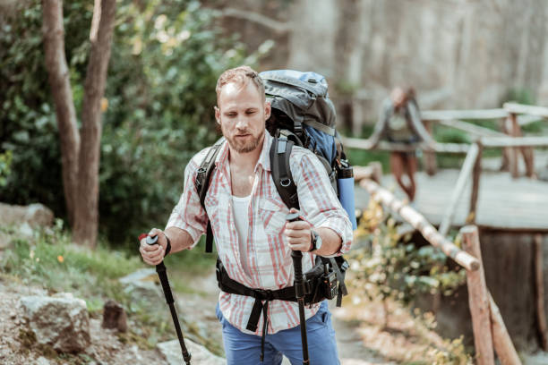 istock Handsome bearded blonde-haired man enjoying his weekend with walking poles 1047677054