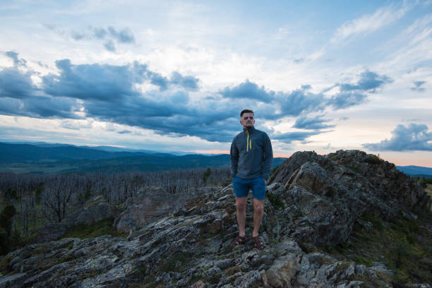 istock Man standing on top of cliff 1047677374