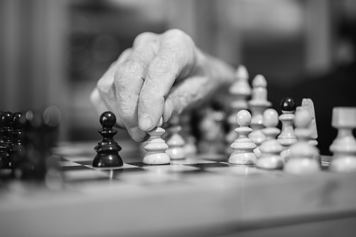 Close-up of an older man playing chess at home