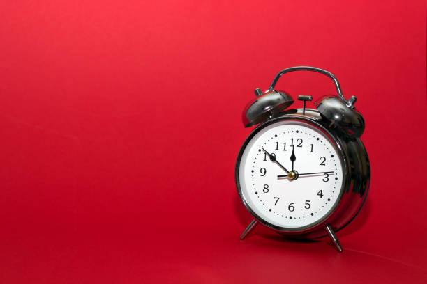 istock red alarm clock on red background. close up shot. top view. 1047684736