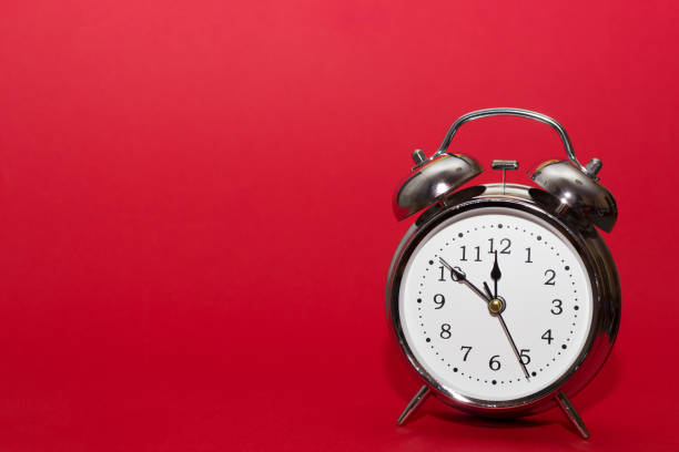 istock red alarm clock on red background. close up shot. top view. 1047684792