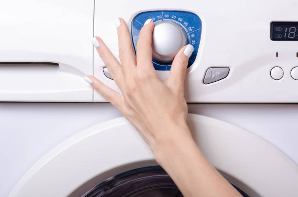 istock Washing machine button female hand housework household 1047691056