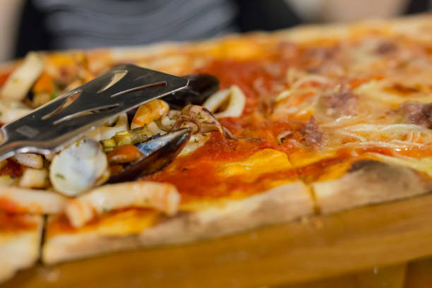 istock image with close-up of seafood pizza at restaurant 1047693818
