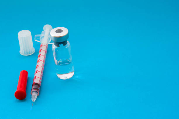 spritze und glas ampulle der impfstoff, insulin, antibiotika oder anderen medikamenten ist auf blauem hintergrund mit leeren bereich für header. konzept-foto für die impfung in der medizin oder behandlung von diabetes mellitus - syringe vaccination vial insulin stock-fotos und bilder