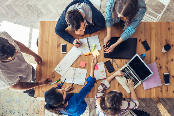 istock overhead view on business people around desk 1047694234