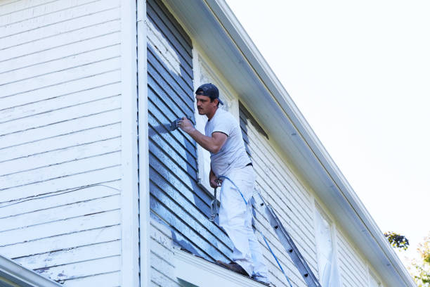 istock Man Brushing Paint On Exterior of Old Home 1047694348