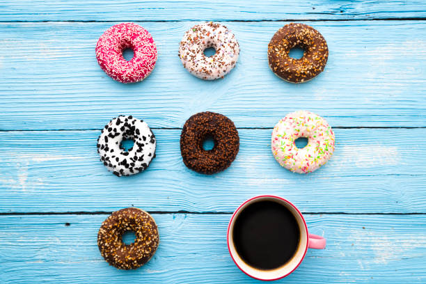 istock Coffee and donuts on wooden background 1047694472