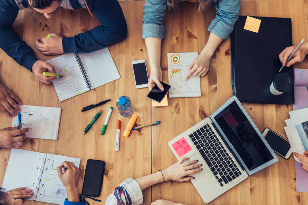 istock overhead view on business people around desk 1047698744