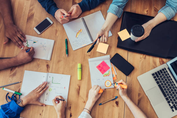 istock overhead view on business people around desk 1047699488
