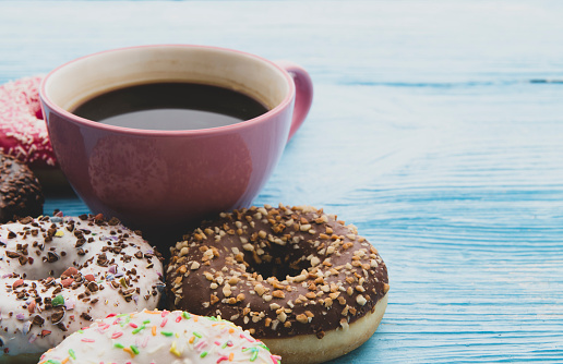 Coffee and donut on wooden blue background