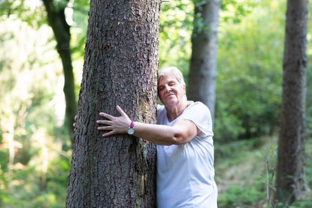 istock Senior woman embracing a tree 1047702646