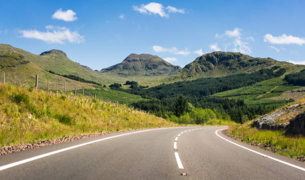 Curving open road in the Scottish Highlands A curving open road near Glencoe in the Scottish Highlands during summer. glencoe scotland photos stock pictures, royalty-free photos & images