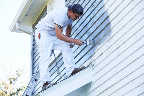 istock Man Brushing Paint On Exterior of Old Home 1047703494