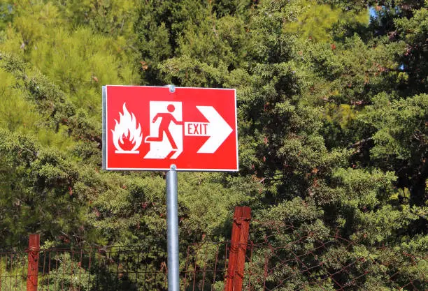 forest fire exit sign showing path to escape from woodland in case of fire