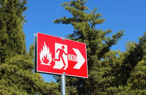 forest fire exit sign showing path to escape from woodland in case of fire